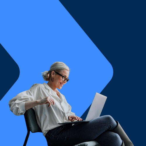 a woman siting smiling looking a computer 