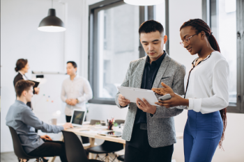 Professionals reviewing documents together in a modern office environment.