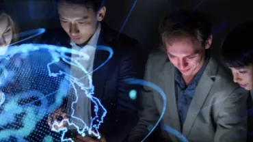 Group of people in business attire with a glowing digital world map overlay.