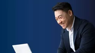 a man smiling looking to a computer