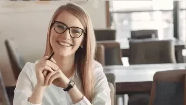 Smiling professional woman wearing glasses at a workplace.