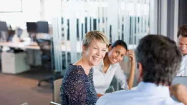 Professionals engaged in a meeting conversation in a modern office