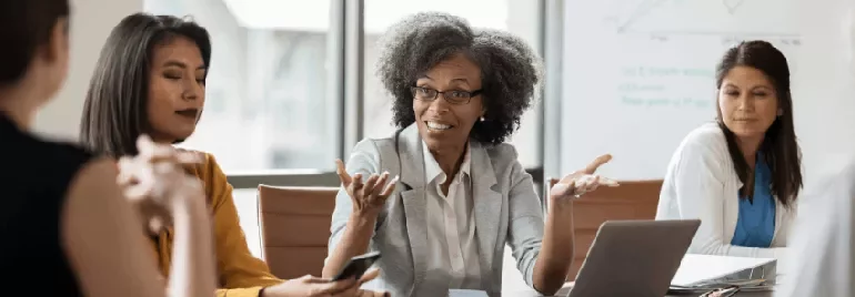 A woman explaining in the office and a group listening to her