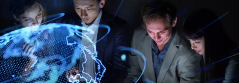 Group of people in business attire with a glowing digital world map overlay.