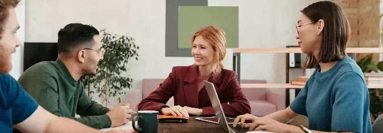 Professionals engaged in a collaborative discussion around a table in a modern office.