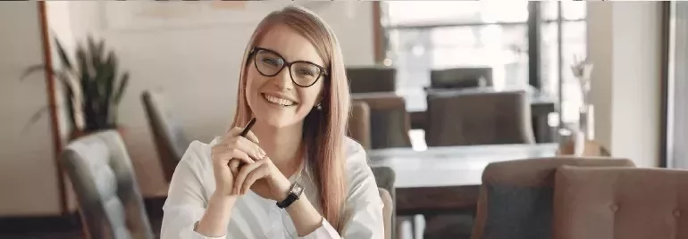 Smiling professional woman wearing glasses at a workplace.